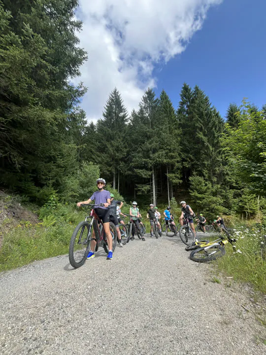 Gruppe mit Mountainbikes macht Pause auf einem Waldweg